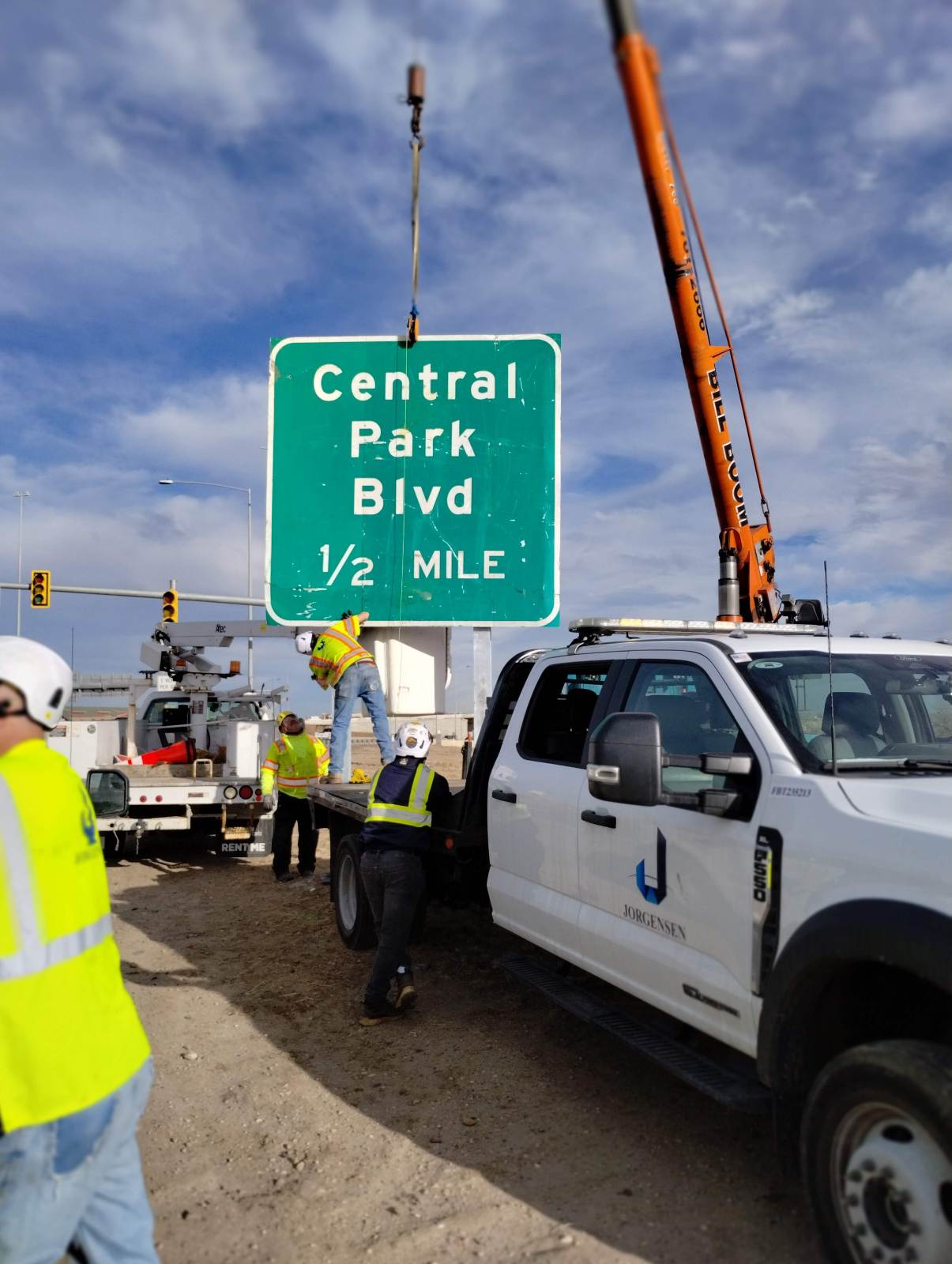 Bill Boom boom truck lifting a green highway sign