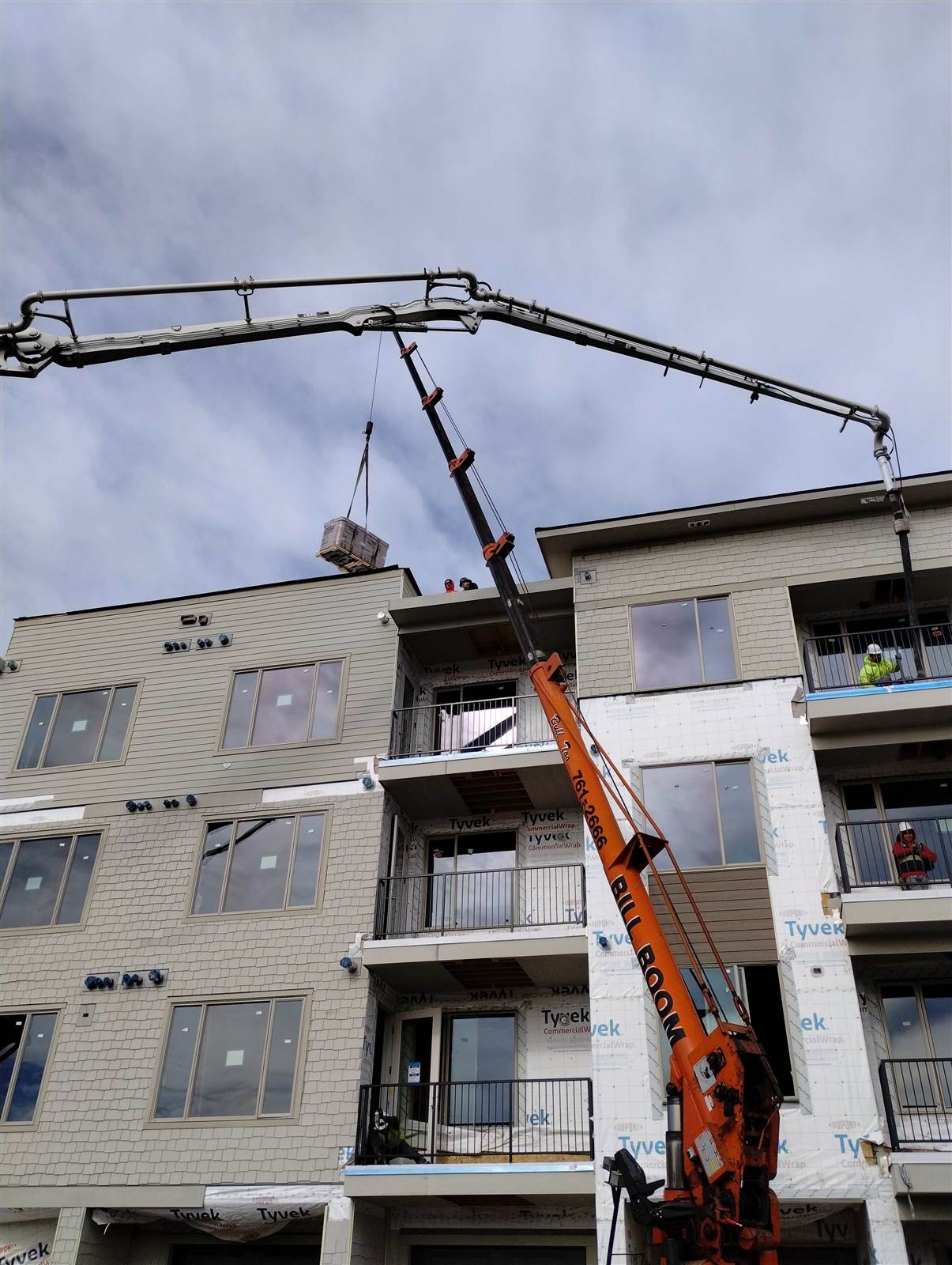 Bill Boom crane setting a rooftop unit on a new apartment complex